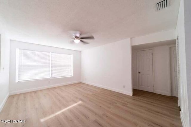 spare room featuring ceiling fan, a textured ceiling, and light wood-type flooring