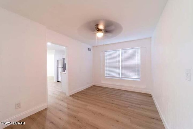 spare room featuring ceiling fan and light hardwood / wood-style flooring