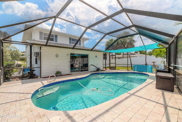 view of swimming pool with glass enclosure and a patio