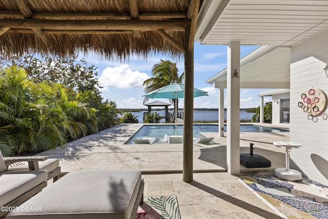 view of swimming pool with a water view, pool water feature, and a patio area