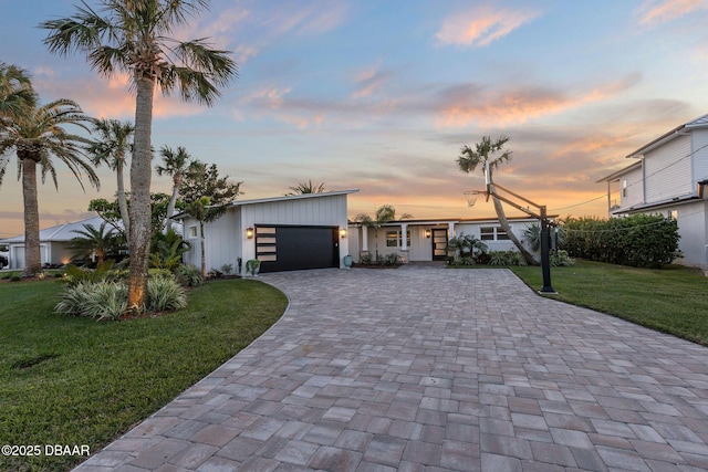 view of front of home with a garage and a yard