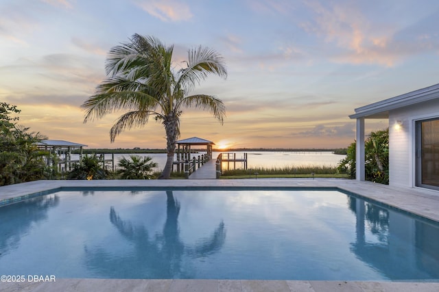 pool at dusk featuring a gazebo and a water view