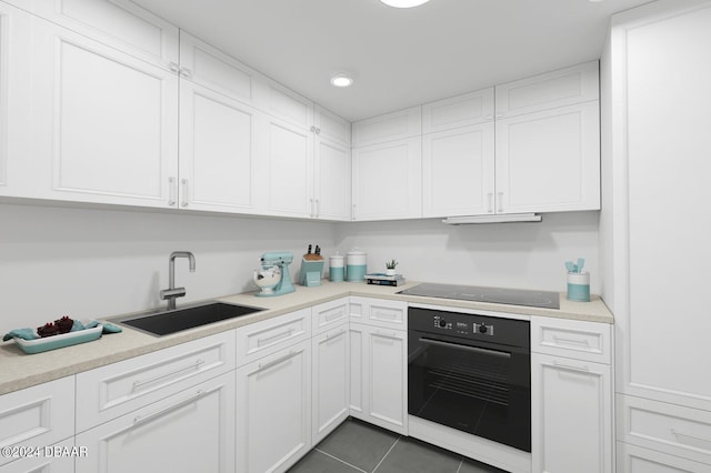 kitchen featuring white cabinets, black appliances, sink, dark tile patterned floors, and ventilation hood