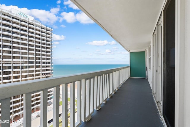 balcony with a water view and a view of the beach