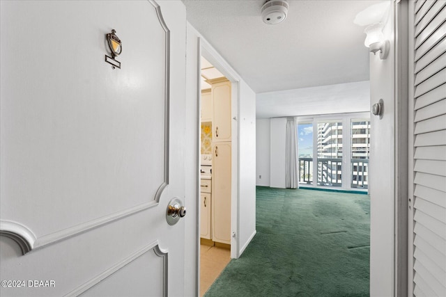 corridor featuring a textured ceiling and light carpet