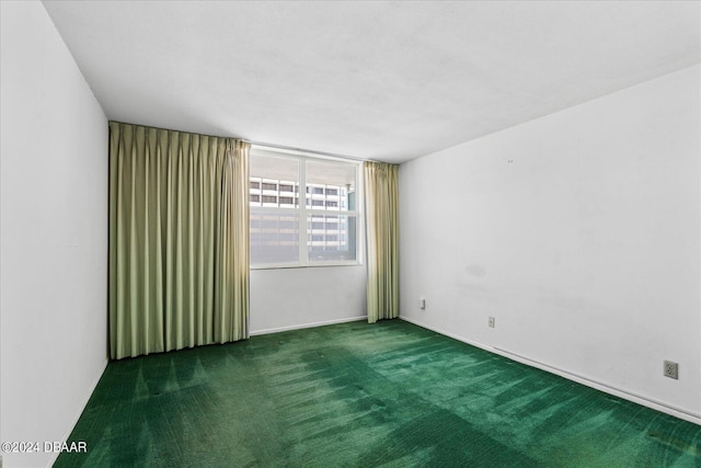 spare room with dark colored carpet