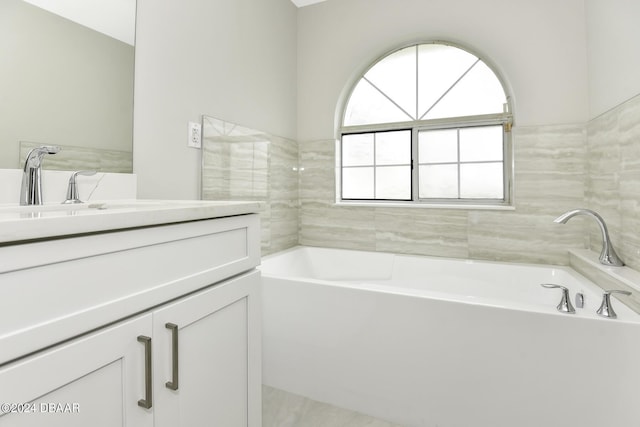 bathroom featuring a garden tub and vanity