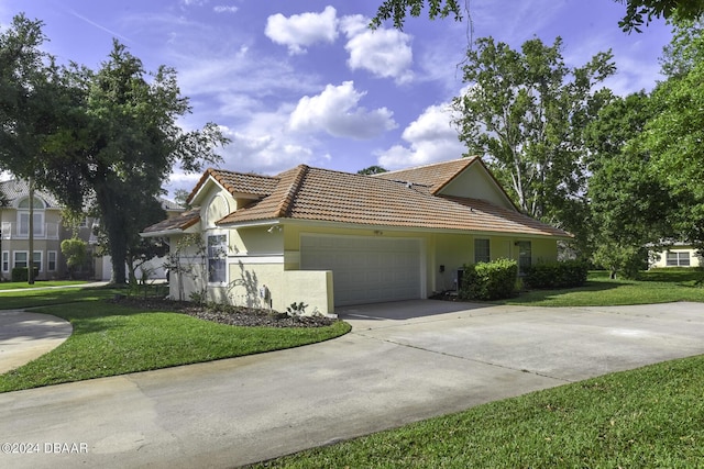 view of front of property featuring an attached garage, a tiled roof, concrete driveway, and a front yard