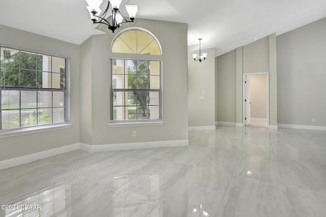 unfurnished room with baseboards, vaulted ceiling, and an inviting chandelier