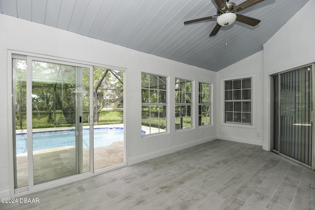 unfurnished sunroom featuring lofted ceiling, wooden ceiling, ceiling fan, and a wealth of natural light