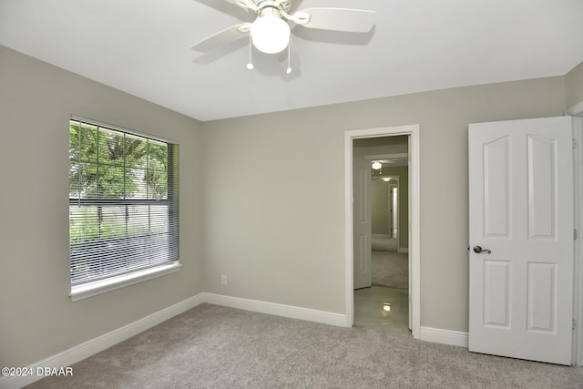 unfurnished bedroom featuring light carpet, baseboards, and a ceiling fan