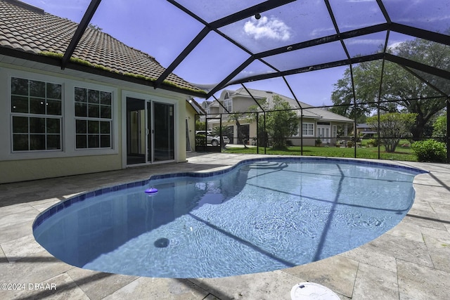 outdoor pool with glass enclosure and a patio