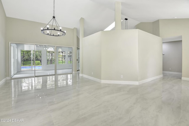 unfurnished room with marble finish floor, high vaulted ceiling, baseboards, and an inviting chandelier