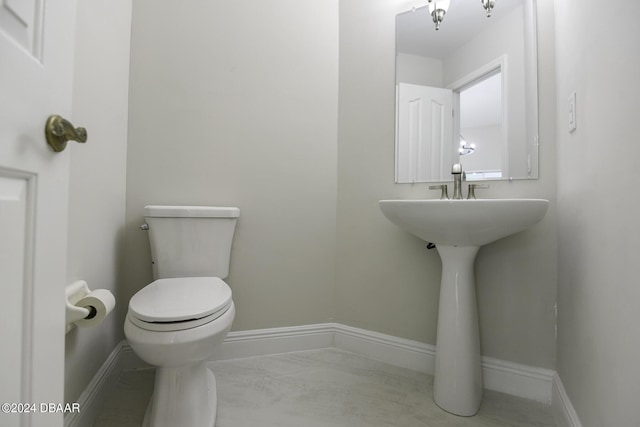 half bath featuring marble finish floor, baseboards, and toilet