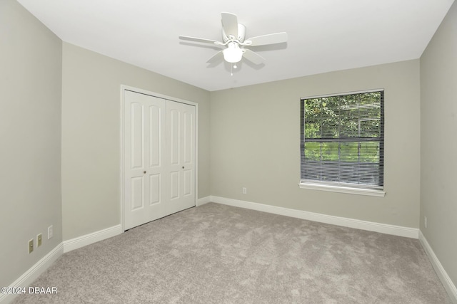 unfurnished bedroom with a closet, carpet flooring, a ceiling fan, and baseboards