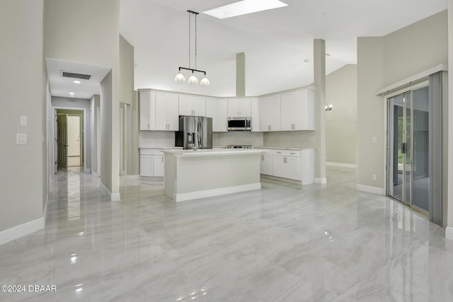 kitchen featuring a towering ceiling, visible vents, white cabinets, light countertops, and appliances with stainless steel finishes