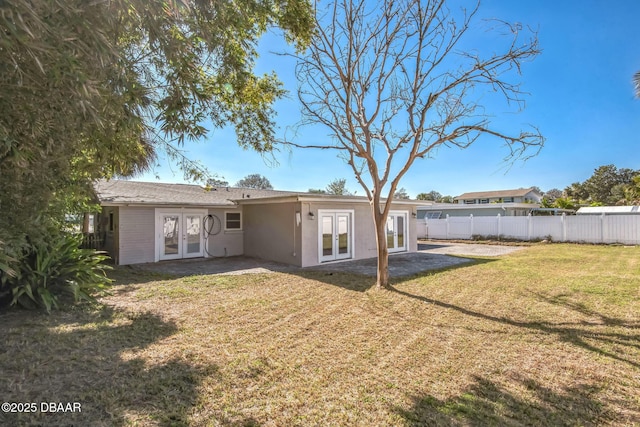 back of house with a lawn, a patio area, and french doors