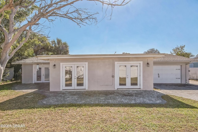 view of front of house featuring french doors, a garage, and a front lawn