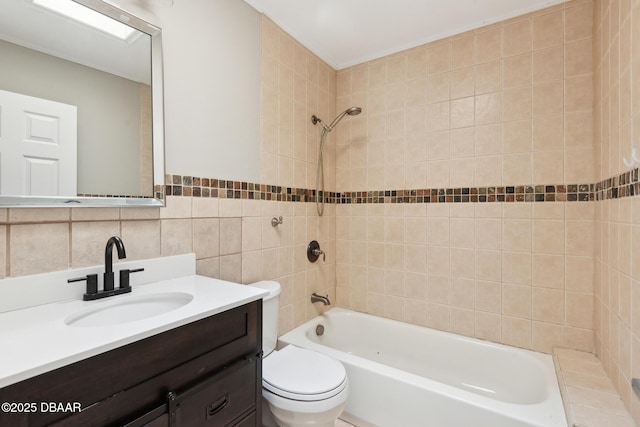 full bathroom featuring vanity, tiled shower / bath combo, toilet, tile walls, and tasteful backsplash