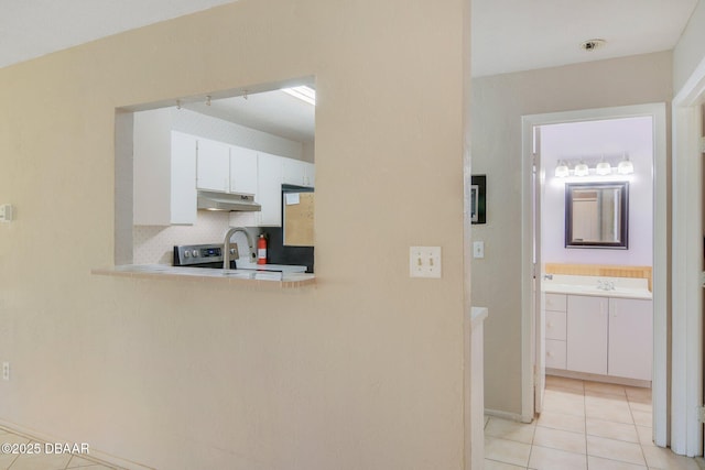 corridor featuring sink and light tile patterned floors