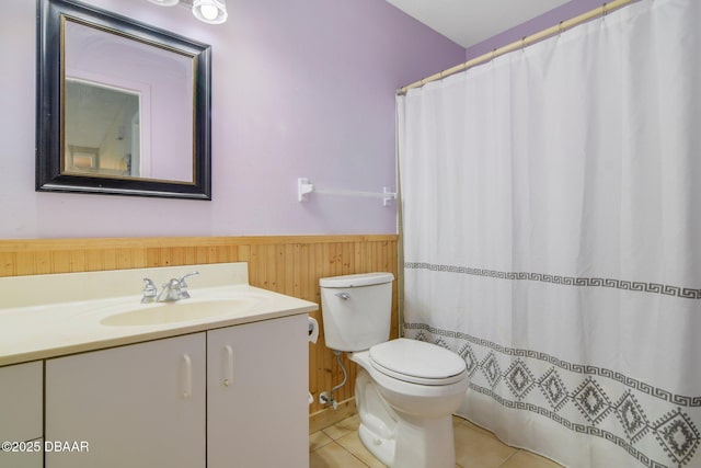 bathroom with toilet, vanity, tile patterned floors, and wooden walls