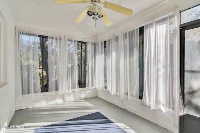 unfurnished sunroom with ceiling fan