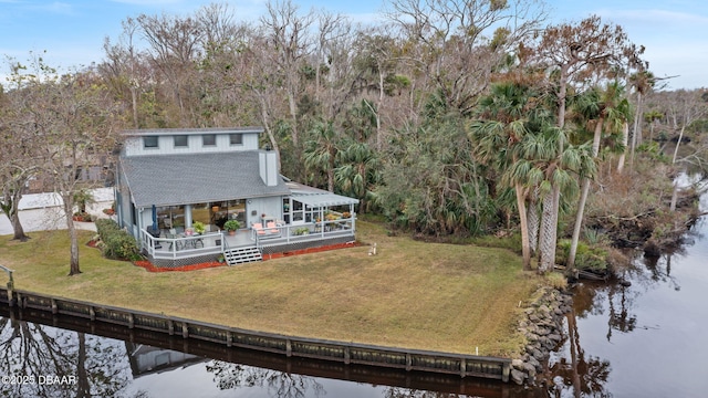 back of property featuring a deck with water view and a lawn