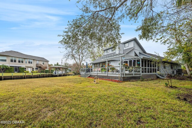 view of yard with a deck and a sunroom