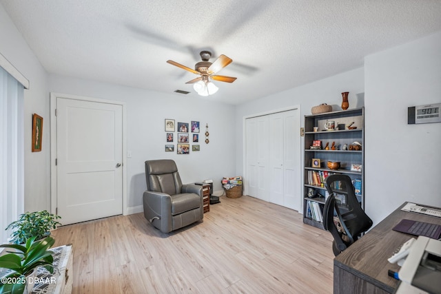 office space featuring a textured ceiling, ceiling fan, and light hardwood / wood-style flooring