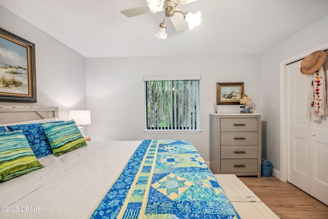 bedroom with ceiling fan, light hardwood / wood-style floors, and a closet