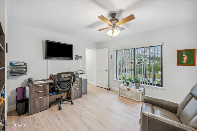 office space with ceiling fan, a textured ceiling, and light wood-type flooring