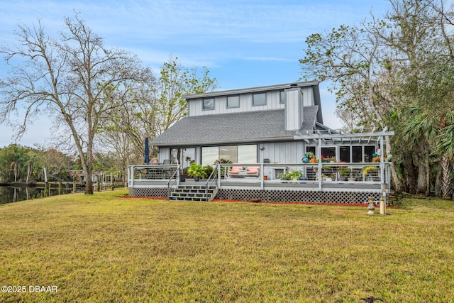 back of property featuring a pergola, a lawn, and a deck with water view