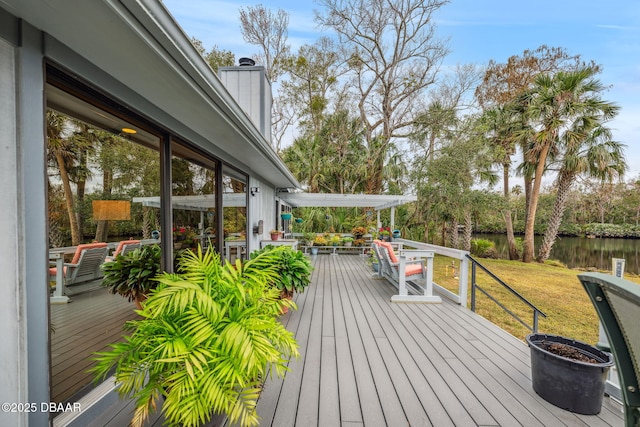 wooden deck featuring a water view, a lawn, and a pergola