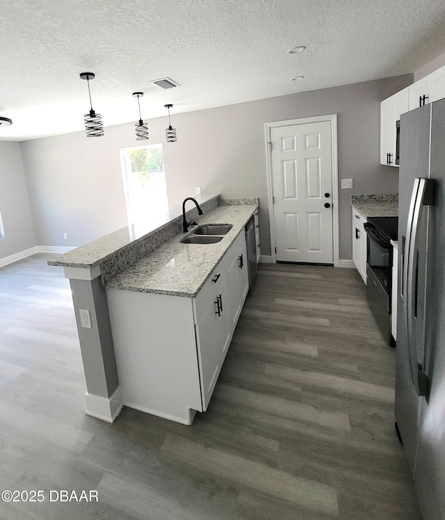 kitchen featuring white cabinetry, stainless steel appliances, a sink, and wood finished floors