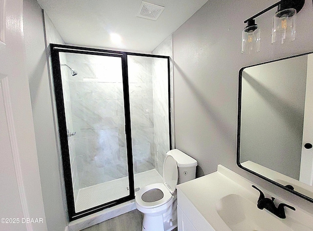 full bathroom with a stall shower, visible vents, vanity, and toilet