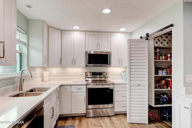 2917 Carriage Dr, South Daytona, FL 32119 - kitchen with appliances with stainless steel finishes, light countertops, white cabinetry, recessed lighting, and a textured ceiling