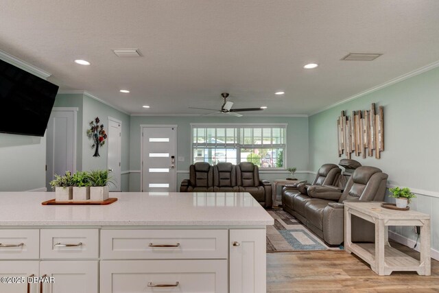 2917 Carriage Dr, South Daytona, FL 32119 - kitchen with ornamental molding, ceiling fan, white cabinets, light wood finished floors, and recessed lighting