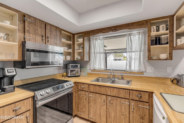 kitchen with hardwood / wood-style floors, stainless steel appliances, a tray ceiling, and sink