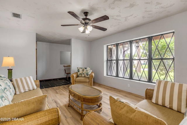 living room featuring light hardwood / wood-style flooring, plenty of natural light, and ceiling fan