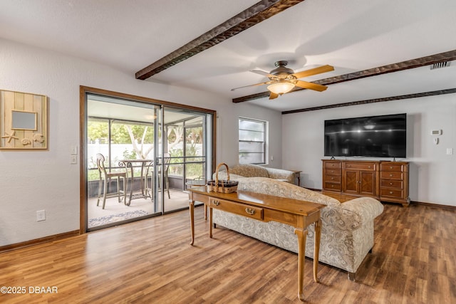 living room featuring beam ceiling, ceiling fan, and hardwood / wood-style flooring