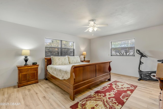 bedroom with multiple windows, light wood-type flooring, and ceiling fan