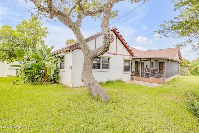 back of house featuring a sunroom and a yard