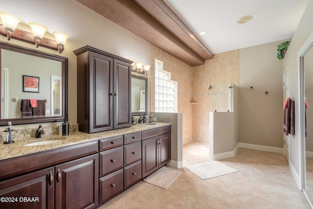 bathroom featuring vanity, tile patterned floors, and a tile shower