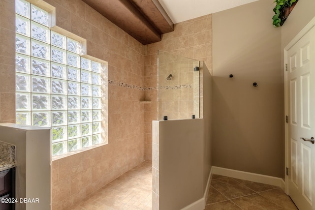 bathroom featuring tile patterned flooring, a wealth of natural light, and a tile shower