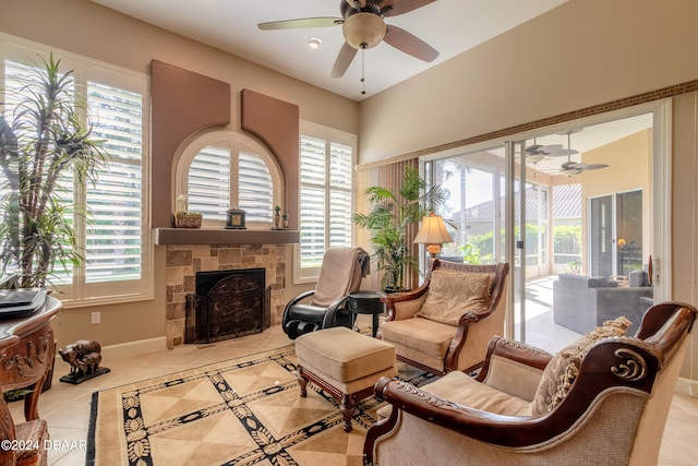 sitting room with light tile patterned floors, ceiling fan, and a fireplace