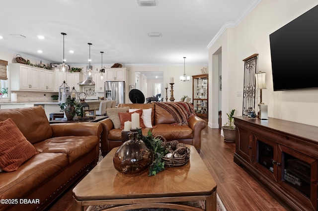 living room with dark wood-type flooring and crown molding