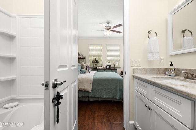 bathroom with ceiling fan, vanity, ornamental molding, and hardwood / wood-style floors