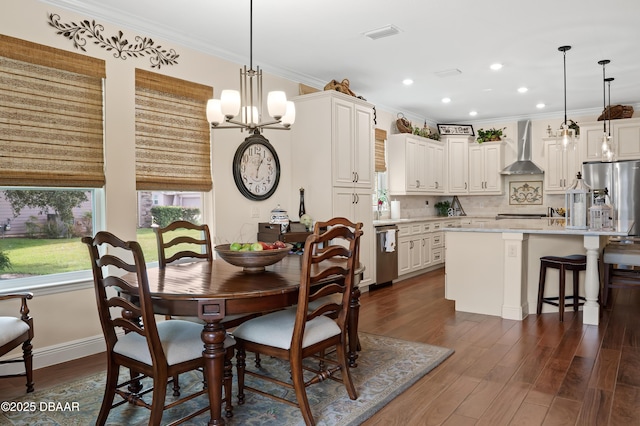 dining space with dark wood-type flooring, crown molding, and a chandelier