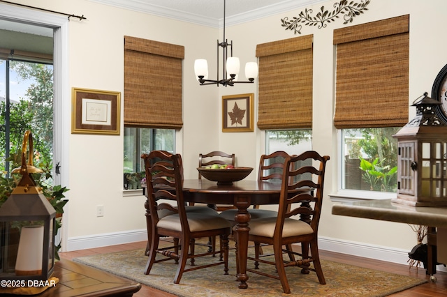 dining area with hardwood / wood-style floors, ornamental molding, and a notable chandelier