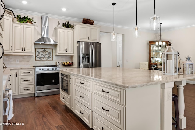 kitchen with a kitchen bar, stainless steel appliances, light stone countertops, wall chimney exhaust hood, and a center island